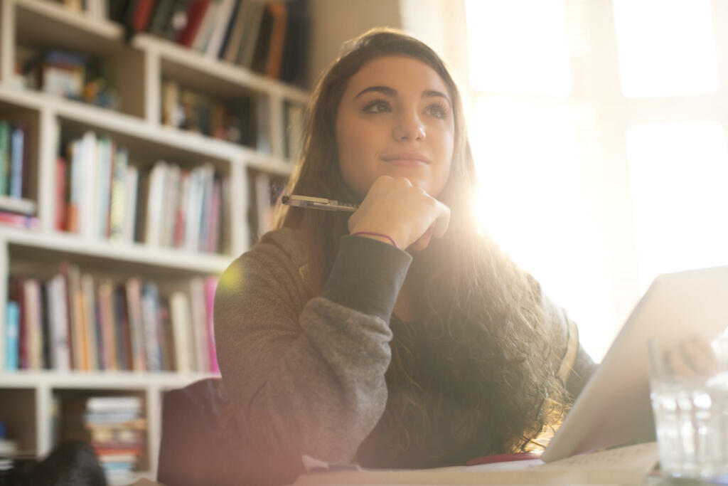 Pensive teenage girl with digital tablet