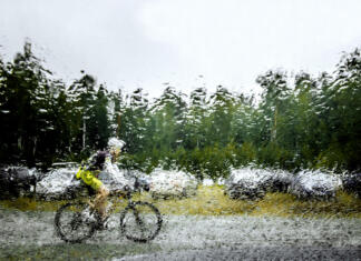 Nasveti za kolesarjenje v dežju Revda, Russia - July 31, 2016: blurred silhouette behind squirt water glass of mountainbiker during Regional competitions on cross-country bike