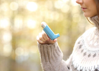 Odkrili nov vzrok za nastanek astme, ki pa ponuja novo rešitev za zdravljenje Woman hand holding asthma inhaler ready to use in winter