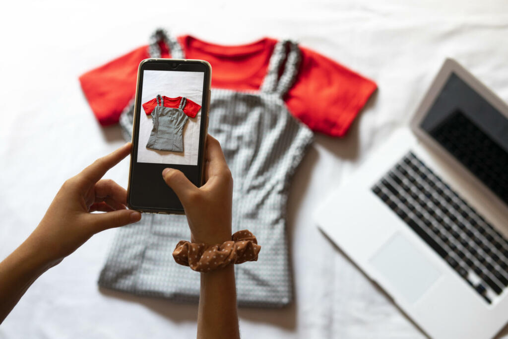 Woman taking a photo of an article of clothing to sell online. in Barcelona, CT, Spain