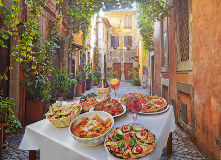 A summer  dinner .Pasta , pizza  and homemade food arrangement  in a restaurant  Rome   .Tasty and authentic Italian food.