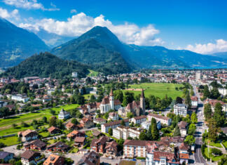 Slovnični nasvet: Kaos z občinskimi imeni Aerial view over the city of Interlaken in Switzerland. Beautiful view of Interlaken town, Eiger, Monch and Jungfrau mountains and of Lake Thun and Brienz. Interlaken, Bernese Oberland, Switzerland.