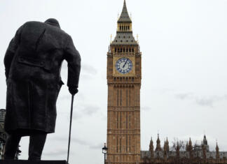 »Ne morem vam ponuditi ničesar, razen krvi, naporov, solz in potu« London, UK - March 15, 2023: A rear view of the statue of Sir Winston Churchill overlooking Big Ben and the Houses of Parliament in Westminster, London, England.
