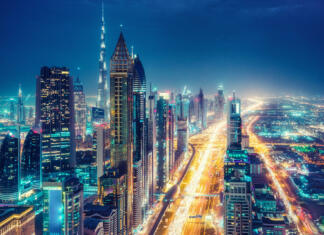 Katera so največja mesta na svetu? Scenic nighttime skyline of a big modern city. Dubai, UAE. Aerial view on famous highways and skyscrapers.