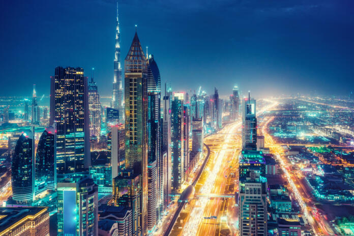 Scenic nighttime skyline of a big modern city. Dubai, UAE. Aerial view on famous highways and skyscrapers.