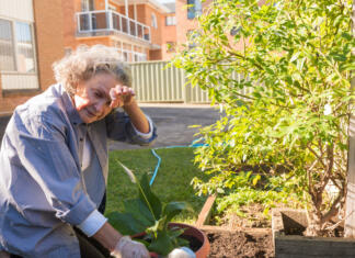 Zaradi te zdravstvene težave bo umiralo višje število ljudi Senior woman rubbing forehead while gardening outdoors - tiredness concept (selective focus)
