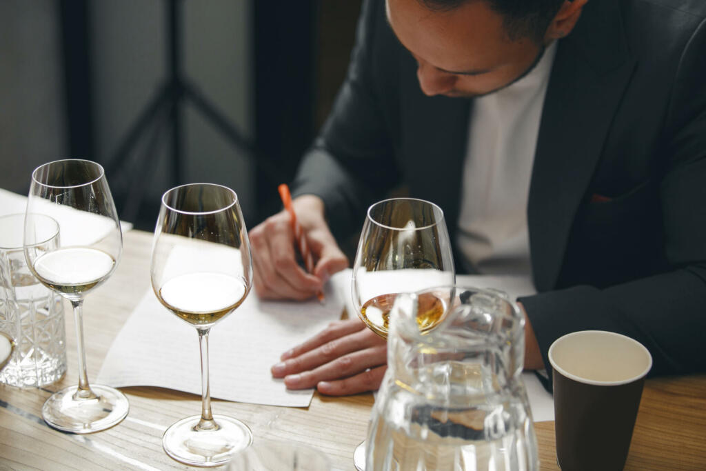 Sommelier makes notes on the tasting card. Blind tasting of wine, close up. Winemaking training school