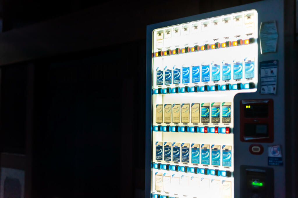 Takayama, Japan - April 8, 2019: Automatic vending machine outdoors outside on street selling smoking cigarettes by Japan Tobacco company called Mevius and Seven Stars packs at night