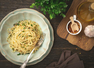 Top 3 italijanski recepti za testenine, ki se jih lahko loti vsak Top view plate of spaghetti AGLIO E OLIO and ingredients on wooden background