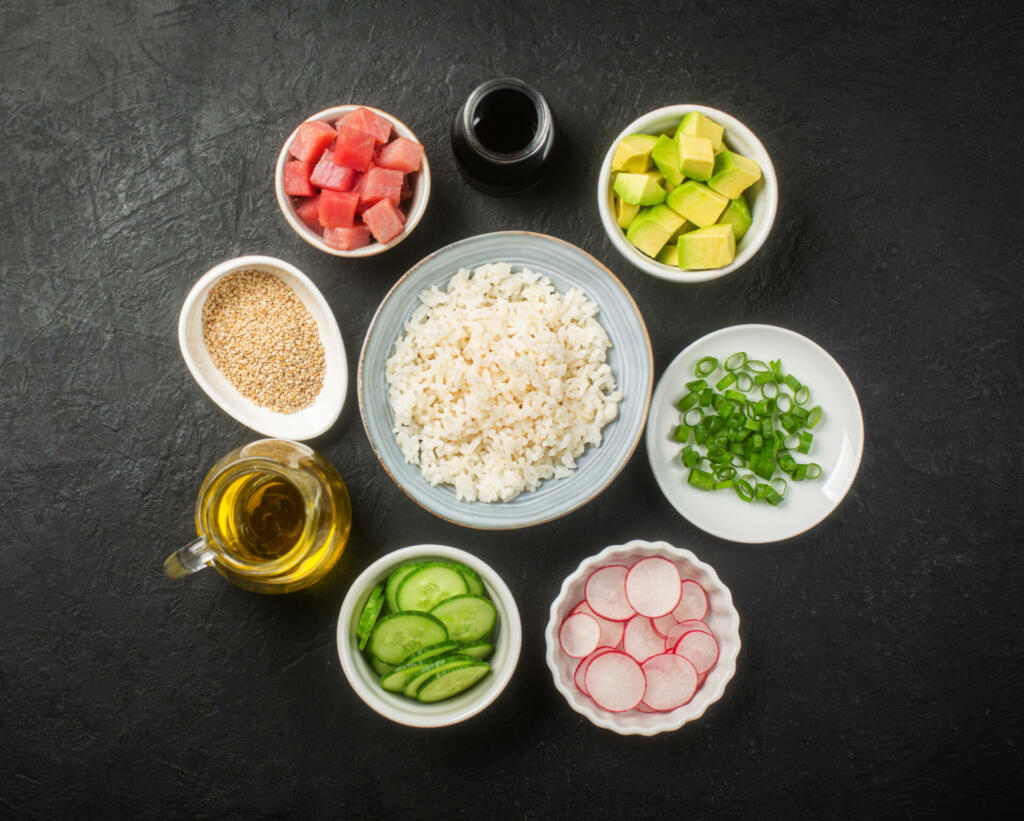 Traditional Hawaiian Poke Bowl prepared with Tuna Fish, rice and vegetables, dark background