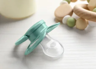 Slovenske mamice so izbrale najboljše tolažilne dude! Baby pacifier on white wooden table, closeup