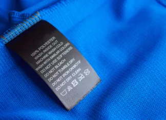 Poliester v oblačilih: varen ali hudo strupen? Black laundry care washing instructions clothes label on blue jersey polyester sport shirt