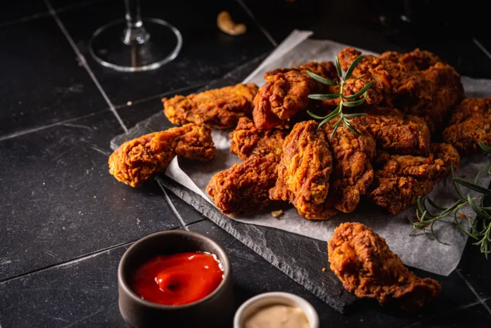 Buffalo style chicken wings served with cold beer on dark background