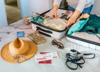 Brez teh 10 stvari ne smeš na potovanje Unrecognizable woman preparing suitcase for summer holidays on the bed