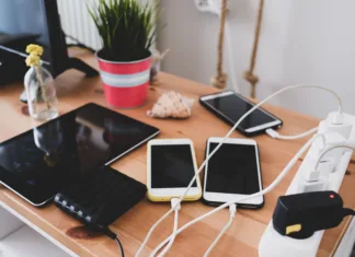 Brez teh elementov ni moderne pisarne chargers and mobile phones on the table, technoliji charging system.