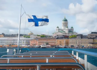 Top 10 Helsinki, najlepše destinacije finske prestolnice Helsinki skyline boat view with Finnish flag and Helsinki Cathedral - Helsinki, Finland
