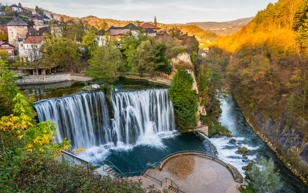 Jajce town and waterfall in Bosnia and Herzegovina, Europe. Beautiful Pliva waterfall under the old town city in the autumn evening.