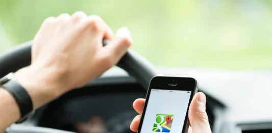 Kiev, Ukraine - May 16, 2014: Man in the car planning a route using a Google Maps application on Apple iPhone 5S. Google Maps is a most popular web mapping service for mobile  provided by Google inc.