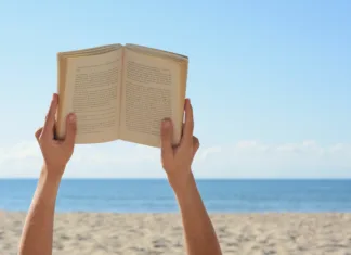 5 modernih španskih avtoric, ki jih moraš prebrati Woman reading book on beach near sea, closeup. Space for text