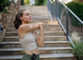 Najboljša vadba za bolnike z diabetesom ni enaka za oba spola Beautiful diabetic woman preparing for outdoor run in the city. Young woman wearing an insulin pump during exercising. Concept of exercise and diabetes.