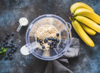Je proteinski smuti dobra izbira za zajtrk? Blueberry protein powder in blender, smoothie preparation, top view. Concept of fitness healthy eating, clean eating, sport lifestyle