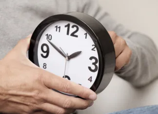 Ali je premik ure zdrav za naše telo? closeup of a young caucasian man adjusting the time of a clock