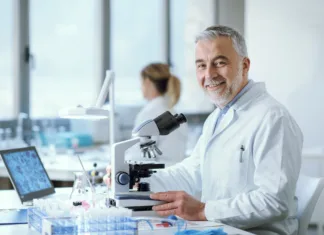 Zakaj si raziskovalci ne upajo tvegati več? Confident smiling researcher sitting at desk and working in the medical lab