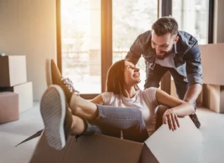 Nasveti za selitev, ki bo potekala organizirano in brez stresa Happy couple is having fun with cardboard boxes in new house at moving day.