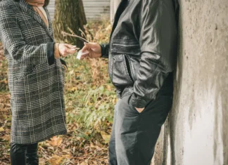 Pred ljubljansko srednjo šolo konzumiral drogo, ukrepov še ni Male drug dealer sells hard drugs in a transparent plastic bag to an addicted woman with money in her hand, cropped image.