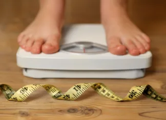 Hranili, ki sta ključni za izgubo telesne teže Overweight girl using scales near measuring tape on wooden floor, selective focus