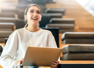 Kako pripraviti odličen zagovor diplomske naloge? young attractive asian female business woman communication with smartphone and laptop white dress cheerful and smile with confience sitting at modern design wooden stand seat