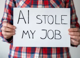 Je tvoja služba ogrožena? Katera dela bodo najprej avtomatizirana Anonymous person holding sign with inscription "AI stole my job". They have sense of loss and helplessness in face of technological advancements reshaping workforce