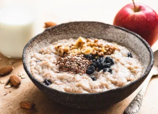 Oatmeal in porridge – poznaš razliko? Breakfast porridge oats with seeds and raisins, closeup view. Healthy food