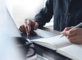 Katera orodja ti lahko pomagajo pri citiranju in navajanju virov? Business woman hands with a pen writing on notebook planner and browsing the internet on laptop computer. Business woman planning, online working on laptop computer, project planning