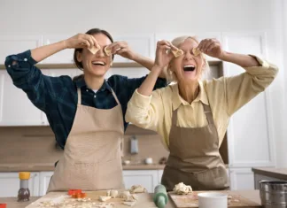 Vse o peki piškotov: napotki, napake in triki Cheerful excited senior mom and young adult daughter woman baking cookies at home, having fun, making biscuit glasses, holding shaped pieces of dough at eyes, laughing, posing for funny portrait