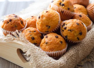 Skrivnosti in nasveti peke mafinov Little chocolate muffins in paper cupcake holder on the wooden tray with sacking napkin