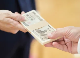 Japonska v krizi, to se je zgodilo prvič po 38 letih A man in a suit handing over money