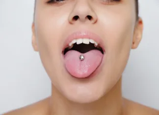 Tako ljudje pirsinge povezujejo s privlačnostjo in inteligenco Beautiful woman sticking out her tongue and showing her young piercing