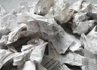 Ali lahko račune mečemo v smeti? Sem sodi papir za račune Close-up of many crumpled receipts from stores. The concept of shopping and purchases.