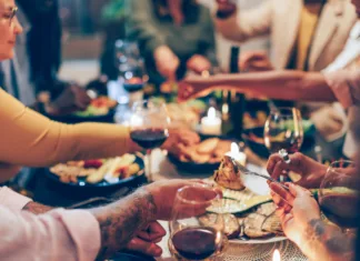 Martinovo brez mesa: Kako pripraviti pojedino, v kateri bodo uživali tudi vegetarijanci? family sitting at the table - vegan friends having dinner together - fucus in the foreground