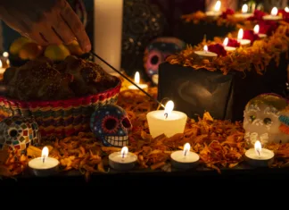 Alternativne sveče za 1. november + kako izdelati svečo doma Hand holding incense stick over "ofrenda" for the Day of the Dead in Puebla, Pue., Mexico