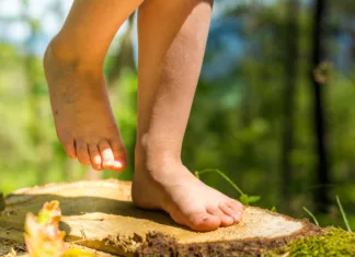 Znanost kaže, da je to najboljši pokazatelj staranja Happy barefoot girl child standing on tree trunk in the woods.