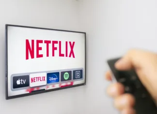 Nepričakovana odločitev Netflixa: Nič več le pretočnik Calgary, Alberta. Canada Dec 9 2019: A Person holds an Apple TV remote using the new Netflix app with a hand. Netflix dominates Golden Globe Nominations. Illustrative