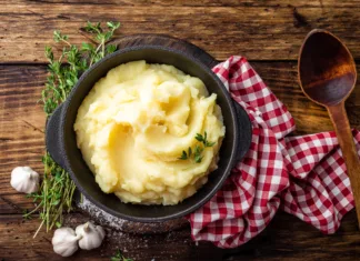 Študent kuha: Kako skuhati pire krompir? Mashed potatoes, boiled puree in cast iron pot on dark wooden rustic background, top view