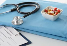 Največja skrivnost medicine: Placebo in njegov zlobni dvojček ‘necebo’ stethoscope a glass of water and pills on a uniform.