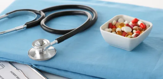 stethoscope a glass of water and pills on a uniform.