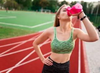 So pre-workout dodatki varni? Učinkovito vadbo dosežeš tudi z drugimi metodami Tired runner drinks water from a bottle