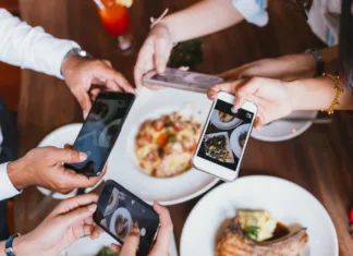 Katere prehrambene trende prinaša leto 2025? Group of friends going out and taking a photo of Italian food together with mobile phone