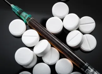 Captagon – droga, ki poganja svetovni terorizem Opioid epidemic and drug abuse concept with closeup on a heroin syringe or other narcotics surrounded by scattered prescription opioids. Oxycodone is the generic name for a range of opioid painkillers