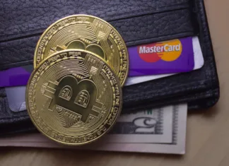Kaj je kripto denarnica? Bodo rekordni zneski na varnem Petrozavodsk. Karelia. Russia. November 26. 2017: Two coins of bitcoin on a black wallet with dollars and a card mastercard